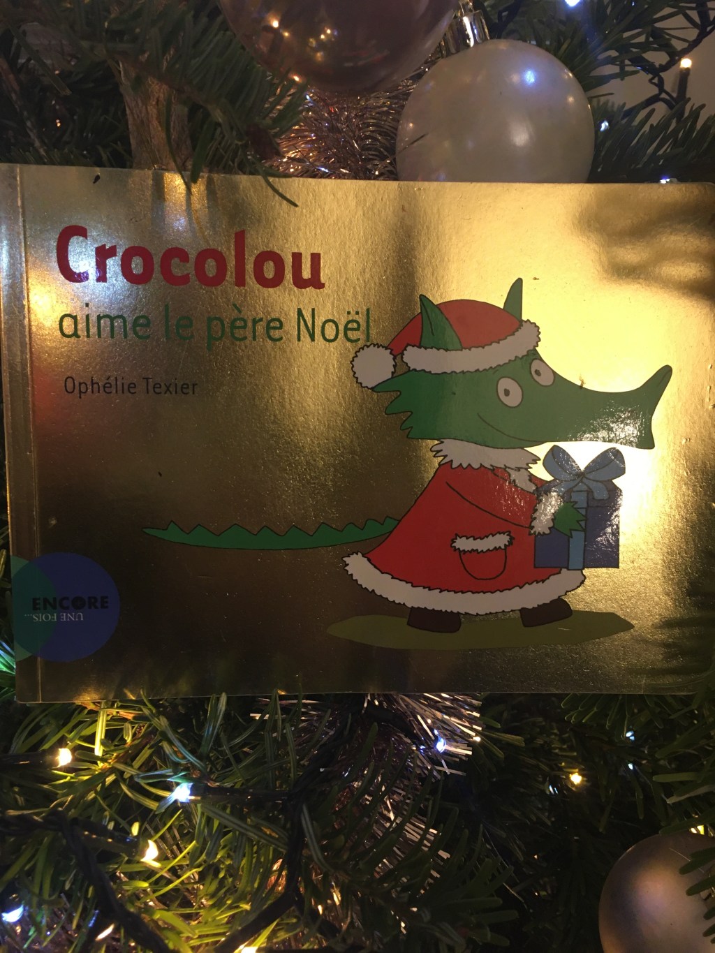 Crocolou déguisé en père noël porte un cadeau